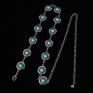 Detail of silver chain belt with round turquoise stones and sunburst metal carvings