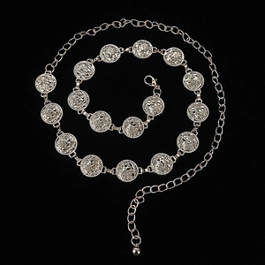 Detail of silver bohemian metal waist chain featuring carved coins and bell on black background