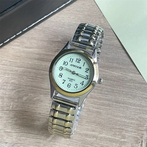 Detail shot of female elastic steel quartz watch with white dial and large numerals