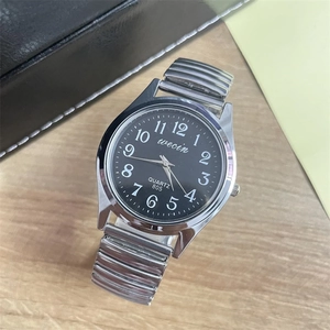 Detail of quartz watch with silver elastic metal strap and large Arabic numerals