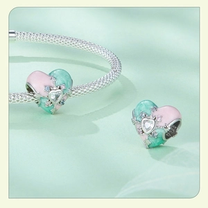 Macro shot of 925 silver heart charm with pink and mint enamel and sparkling zircon