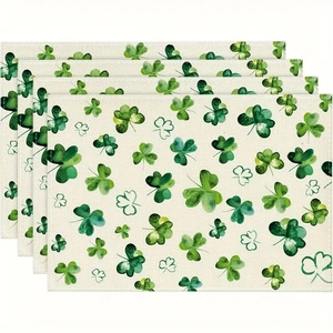 Close-up of four linen placemats with green clover patterns for St. Patrick's Day