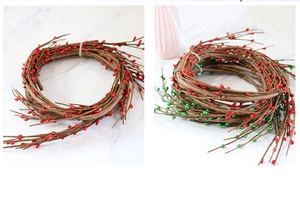 Détail d'une guirlande de baies de Noël artificielles rouges et vertes sur marbre