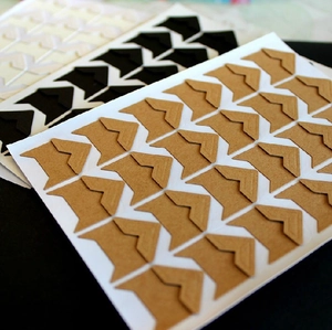 Detailed view of DIY photo corner stickers in brown, black and beige kraft paper