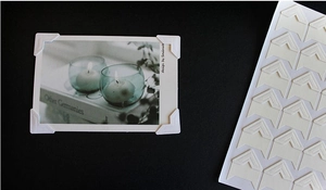 Close-up of white paper photo corners for DIY scrapbooking and album assembly