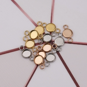 Close-up of polished stainless steel round bezel pendant trays in gold, silver, and rose gold