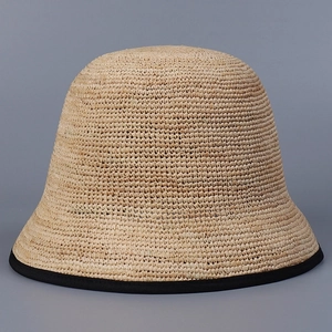 Detailed view of the fine straw weave texture and black ribbon edging on a bucket hat