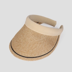 Detail of hand-woven straw visor featuring beige fabric trim and textured patterns