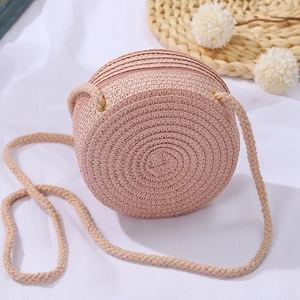Dettaglio ravvicinato della borsa a tracolla rotonda in paglia intrecciata rosa