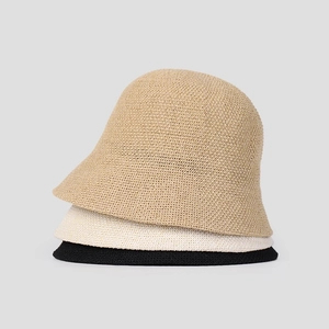 Three minimalist knitted bucket hats in khaki, beige, and black with fine woven texture