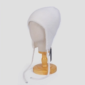 Detailansicht der weißen Angora-Fellmütze mit Ohrenklappen und Strickstruktur