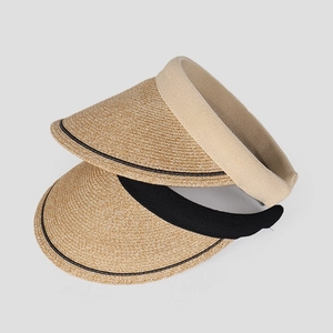 Detail view showing beige and black straw woven open top sun hats with textured finish