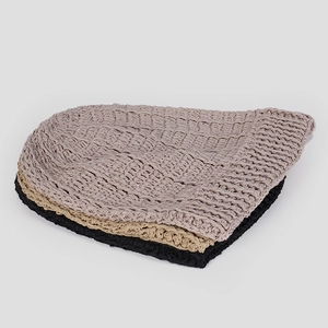 Dettaglio macro di berretti in maglia di lino di qualità in grigio, beige e nero