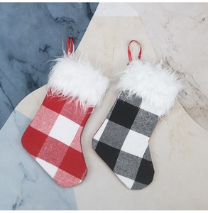 Close-up of checkered Christmas stockings with plush white faux fur trim and red hangers