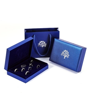 Royal blue jewelry gift set featuring a textured paper bag and two premium ring boxes