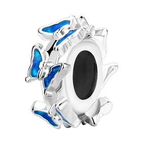 Macro detail of silver charm with blue enamel butterflies and polished metal finish