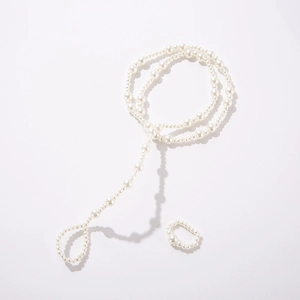 Detailed view of elegant white pearl foot anklet and matching ring set on white background