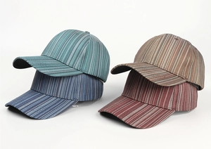 Detail view of four striped tie-dye baseball caps in blue, navy, khaki, and brown shades