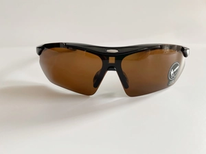 Macro detail of sports safety sunglasses with large brown curved lenses for eye protection