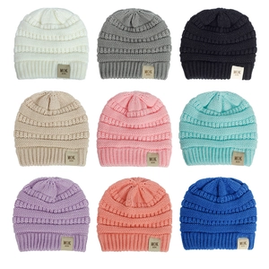Detail view of nine color options for soft knitted baby hats with MOK KIDS labels