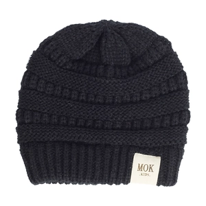 Close-up of black knit baby beanie featuring clear MOK KIDS textile label stitching