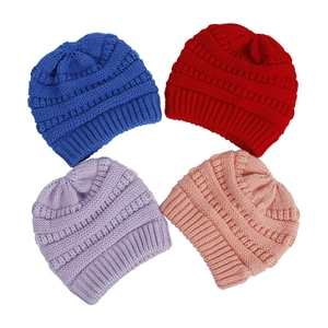 Detail of four colorful winter knit hats showing thick ribbed texture and warm yarn