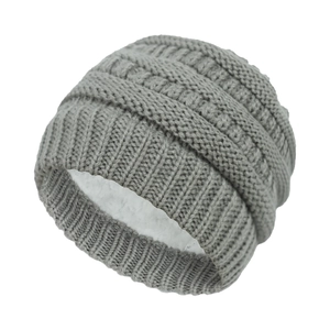 Detailed view of winter knit hat featuring grey cable pattern and thick white fleece lining