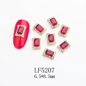 Detail of ruby red nail art charms with gold alloy base and crystal rhinestones