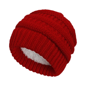 Close-up of red cable knit winter hat with thick white fleece lining for warmth