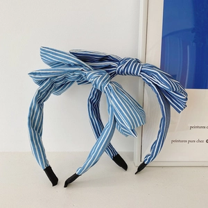 Detail view of two blue and white striped fabric headbands with large bow decoration