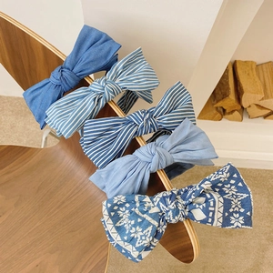Detail of four blue denim fabric headbands with bowknots in solid, striped, and patterned styles