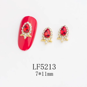 Detailed macro view of 7x11mm ruby red teardrop nail crystal with gold base and rhinestones
