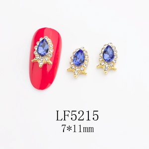 Detailed view of 7x11mm sapphire blue teardrop nail rhinestones on red mannequin nail