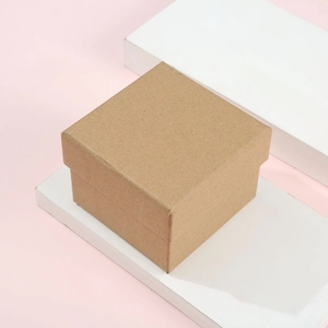 Minimalist square brown kraft paper jewelry gift box with lid on a modern pink background