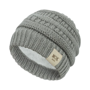 Close-up of grey knit baby hat showing thick cable pattern and warm fleece lining