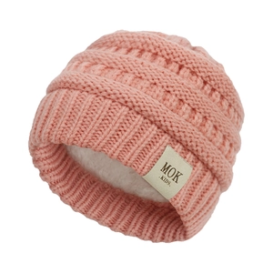 Detail of pink cable knit baby hat featuring warm white fleece lining and MOK logo