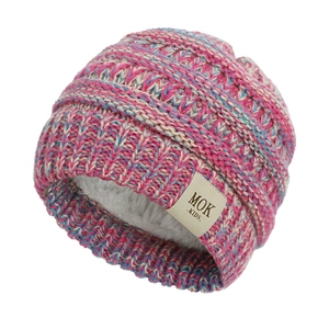 Detail of pink and blue knit baby hat showing warm fleece lining and leather brand tag