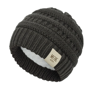 Close-up of knit baby hat featuring plush fleece lining and detailed cable stitch texture