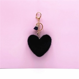 Detail of soft black plush heart keychain with gold clasp and blue tassel charm