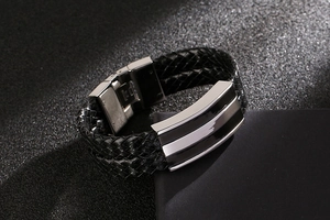 Macro view of woven black leather textures and polished stainless steel magnetic clasp