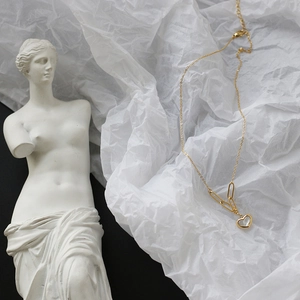 Detail of 18K gold-plated heart necklace with white shell inlay and paperclip chain