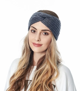 Close-up of a grey knitted cross headband worn by a model for a stylish winter look