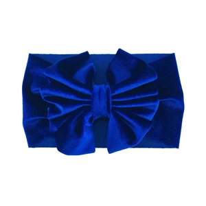 Detail of royal blue velvet baby headband featuring a large multilayered bow design
