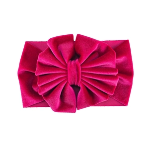 Detailed view of large magenta velvet bow headband with soft elastic fabric texture