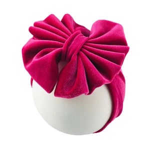 Detail view of large magenta velvet bow headband with soft texture and elastic wide band