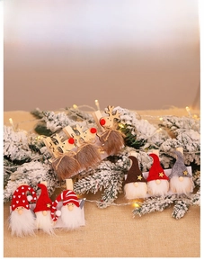Close-up of wooden Christmas gnome and reindeer clips with warm festive holiday decorations