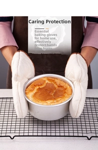 Detailed view of thick heat-resistant cotton gloves holding a fresh cake mold in kitchen