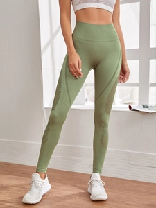 Detail der olivgrünen nahtlosen Yogahose mit hohem Bund und lasergeschnittenen Mesh-Löchern