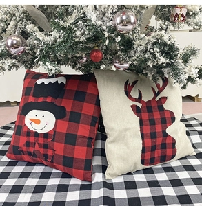 Detailed close-up of red plaid Christmas pillow covers featuring reindeer and snowman