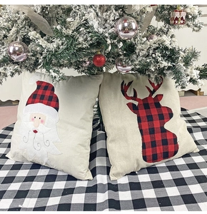 Detail of Santa and reindeer linen pillow covers with red plaid on a beige base